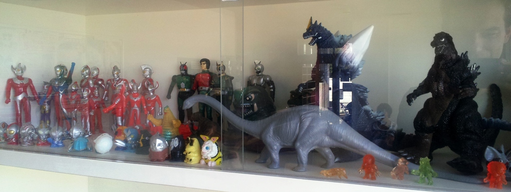 Ultraman, Godzilla and Dinosaur figurines on a shelf