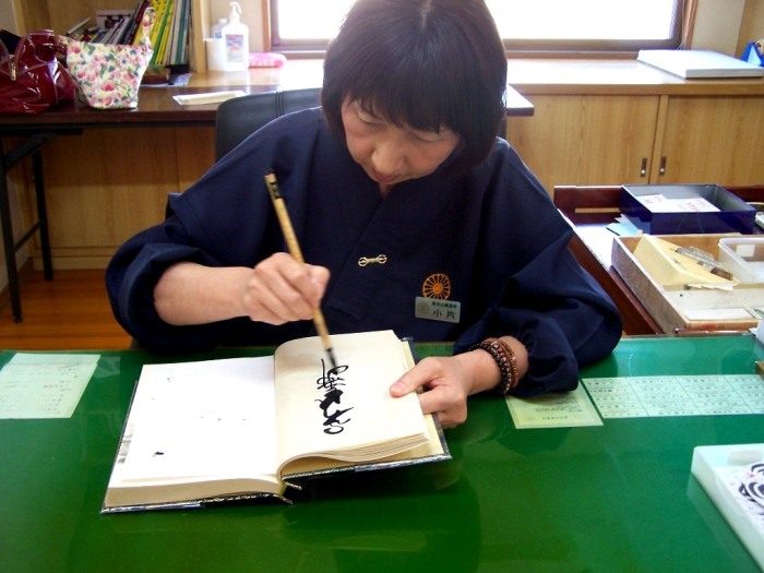 Signing the Shikoku pilgrim book in Zentsu-ji