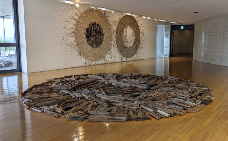 Inland Sea Driftwood Circle (on the floor) and River Avon Mud Circles by the Inland Sea (on the wall) by Richard Long (1997)